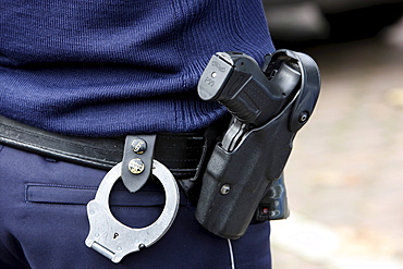 Police, police officer with handcuffs and service weapon, Walther P99, in the holster