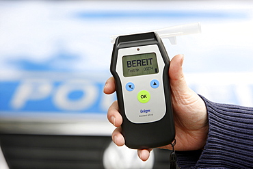 Police officer with breathalyser for checking the fitness to drive