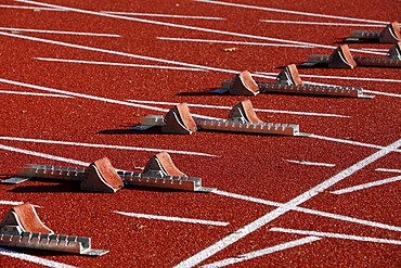 Tartan track of a sports field, starting blocks for sprinting disciplines, lane markings