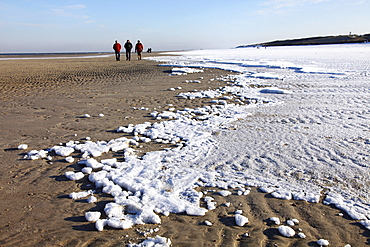 People walking along the snow-covered beach on the East Frisian North Sea island of Spiekeroog, Lower Saxony, Germany, Europe