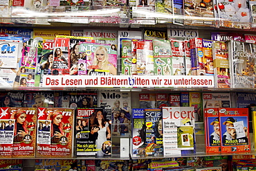 Shelves with magazines in a shop, lettering "Das Lesen und Blaettern bitten wir zu unterlassen", German for "Please refrain from reading or skimming through the magazines"