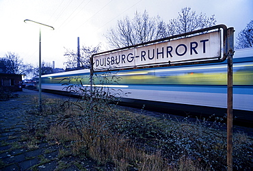 Overgrown platform, train passing, Duisburg-Ruhrort suburban train station, North Rhine-Westphalia, Germany, Europe