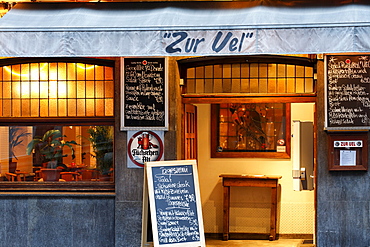 Typical Duesseldorf pub in the historic district, menu board displayed in front of the door, evening mood, Ratinger Strasse street, Duesseldorf, North Rhine-Westphalia, Germany, Europe