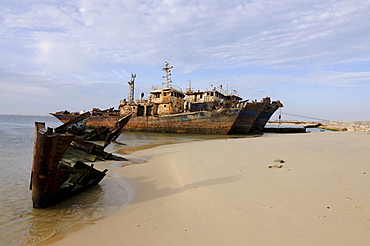 Ship wrecks rusting on the shores of the beach of Nouadhibou, one of the largest ship wreck cemeteries worldwide, Mauritania, northwestern Africa