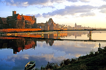 Morning mood with an angler on the Nogat River with Malbork Castle, formerly Marienburg Castle, the seat of the Grand Master of the Teutonic Knights, Malbork, Mazury, Poland, Europe