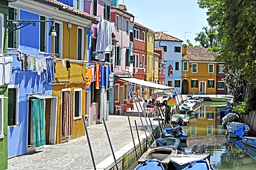 Canal with fishing boats in Burano, a village pub with tourists, fishermen's houses, Burano Island, Venice Lagoon, Venice, Italy, Europe