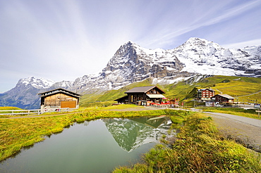 Eiger Mountain reflected in a mountain lake beside a mountain restaurant and Kleine Scheidegg Pass, Canton of Bern, Switzerland, Europe