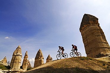 Mountain bikers cycling in Love Valley, Guevercinlik Valley, Goereme, Cappadocia, Turkey