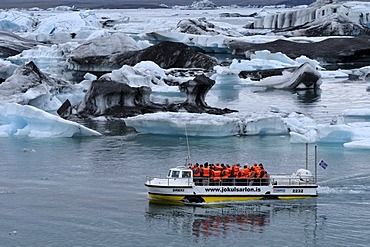 Boat tour passing icebergs in the Joekulsarlon glacial lake, Iceland, Europe