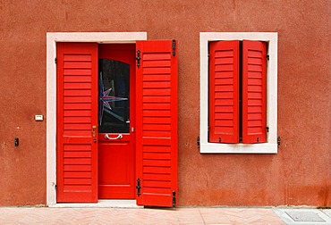 Bright red facade of house, historic town centre of Caorle, Veneto, Italy, Europe