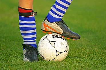 Detail of a soccer player's legs with foot on a football, shoes, football cosk