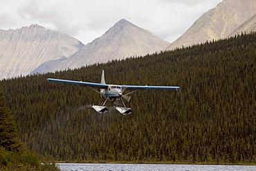 Bush plane, float plane de Havilland Canada DHC-3 Otter taking off from McClusky Lake, Wind River, Mackenzie Mountains, Yukon Territory, Canada