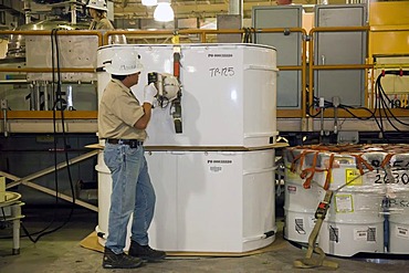 Workers prepare transuranic nuclear waste from America's nuclear weapons program for long-term storage at the Waste Isolation Pilot Plant, here a worker checks radiation levels on the outside of storage containers because they are stored in rooms carved o