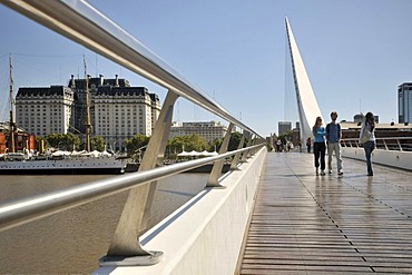 Tourists walking on a modern suspension bridge, Puente de la Mujer bridge, Women's Bridge, in the old harbor of Puerto Madero, Buenos Aires, Argentina, South America