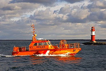 Pilot vessel Pilot Klasshahn passing a lighthouse at the port entrance Rostock-Warnemuende, Mecklenburg-Western Pomerania, Germany, Europe