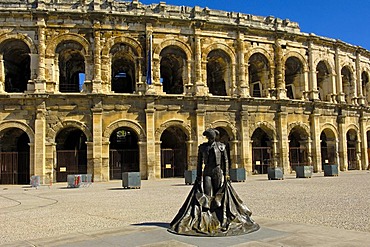 Arenes de Nimes Roman amphitheatre and bullfighter statue, Nimes, Gard, Bouches-Du-Rhone, France, Europe