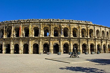 Arenes de Nimes Roman amphitheatre and bullfighter statue, Nimes, Gard, Bouches-Du-Rhone, France, Europe