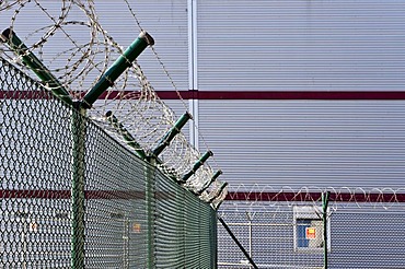 Barbed wire fence in front of a warehouse