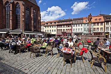 Tourists enjoying the sunshine in the old market square with the Herkulesbrunnen, Hercules Fountain, Heiliggeistkirche, Church of the Holy Spirit, at left, Heidelberg, Rhine-Neckar region, Baden-Wuerttemberg, Germany, Europe