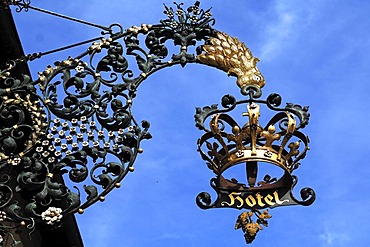 Ornamental wrought-iron inn sign, crown, against a blue sky, Breisacherstrasse 1, Neuenburg am Rhein, Baden-Wuerttemberg, Germany, Europe