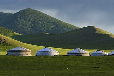 Rain clouds over a yurt camp or ger camp, grasslands on the Orkhon waterfall in front of the mountains of the Khangai Nuur National Park Orkhon Khuerkhree, Kharkhorin, Oevoerkhangai Aimak, Mongolia, Asia