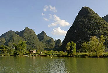 Karst rocks at the Yulong river with bamboo and wooden fishing hut in Yangshuo, Guilin, Guangxi, China, Asia