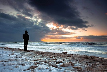 Woman looks over the North Sea at sunset on a winter's day, Sylt Island, Schleswig-Holstein, Germany, Europe