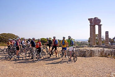 Cyclists at the Temple of Apollo, above Rhodes Town, Island of Rhodes, Greece, Europe