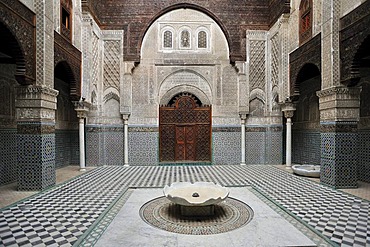 Courtyard of the Medersa Attarine with wash fountain, walls and arches decorated with cedar wood carvings, stucco ornaments and tile mosaics, Fes, Morocco, Africa