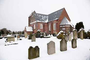 Brick church of St. Johannis with a snowy cemetery, Nieblum village on the North Sea island of Foehr, North Frisian islands, Schleswig-Holstein, northern Germany, Europe