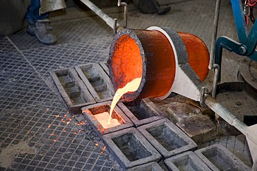 Working in an art foundry, liquid bronze being poured into moulds