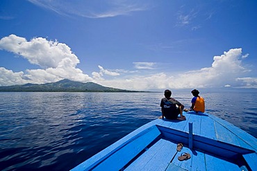 Young couple sitting at the bow of a wooden boat, Siladen island, Sulawesi, Indonesia, Southeast Asia