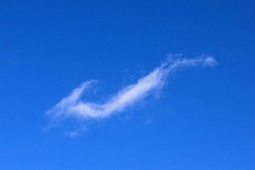 Hook-shaped cirrus cloud in a blue sky, cloud veil