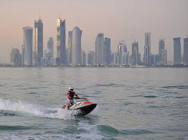 Jet-skiing, jetboat, personal watercraft in front of the skyline of Doha, Qatar, Persian Gulf, Middle East, Asia