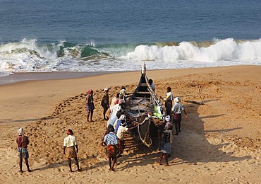 Fishermen pulling their boat on a beach south of Kovalam, Malabar Coast, Malabar, Kerala, southern India, India, Asia