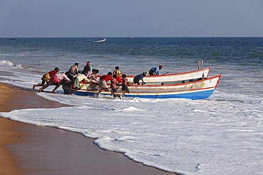 Fishermen pushing their fishing boat into the sea, Somatheeram Beach, Malabarian Coast, Malabar, Kerala state, India, Asia