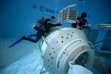 A module of a space station reproduction in a diving basin, backup divers carefully examine the space station, European Space Agency, ESA, European Astronaut Center, EAC, Cologne, North Rhine-Westphalia, Germany, Europe