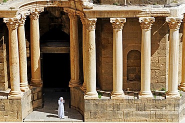 Woman in front of columns, Roman theater in Bosra, Syria, Asia