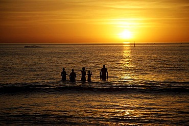 Sunset and swimmers on Glenelg beach, Adelaide, South Australia, Australia