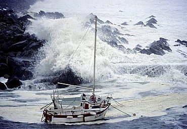 High waves crashing over rocks, rocking small boats, stormy seas on the Brittany coast, hurricane, Finistere, Brittany, France, Europe