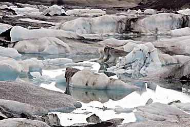 Icebergs in the Joekulsarlon glacial lake with different colorations due to volcanic ash, Joekulsarlon, Vatnajoekull, Iceland, Europe