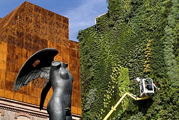 Caixa Forum, by the architects Herzog & de Meuron, with sculpture by sculptor Igor Mitoraj and worker in the vertical garden by Patrick Blanc, Paseo del Prado, Madrid, Spain, Europe