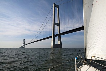 Sail yacht right before passing under the StorebÃŠlt Bridge, Great Belt Bridge, Korsoer, Zealand, Denmark, Europe