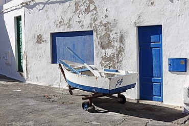 Small fishing boat in front of a house, Caleta de Famara, Lanzarote, Canary Islands, Spain, Europe