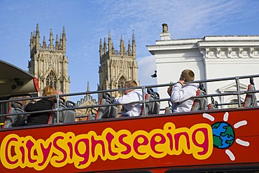 York CitySightseeing, tourist bus, against medieval York with York Minster in the back, Yorkshire, England, United Kingdom, Europe