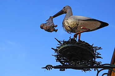 Stork with baby figure in its beak, a children's shop, Obere Bruecke, Bamberg, Upper Franconia, Bavaria, Germany, Europe