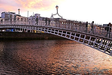 People crossing Halpenny Bridge over the Liffey River, Dublin, Ireland, Europe