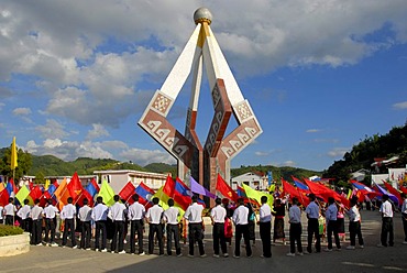 Parade, flag-bearers, young men of the Laotian Youth Organization Lao Youth with many colorful flags standing around a communist monuments, Xam Neua, Houaphan province, Laos, Southeast Asia, Asia