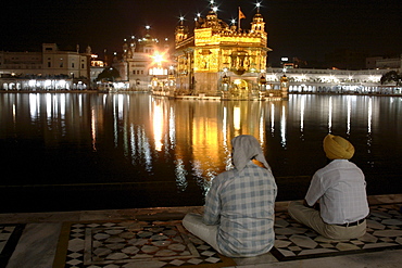 Two men with view of the Golden Temple, Amritsar, Punjab, India, South Asia