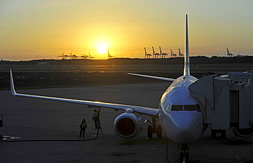 Qantas Airlines Boeing 717 refueling at sunrise, Brisbane International Airport, cranes in the rear, harbour, Brisbane, Queensland, Australia